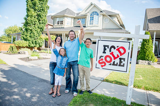 Happy homeowner in front of sold sign in Arkansas